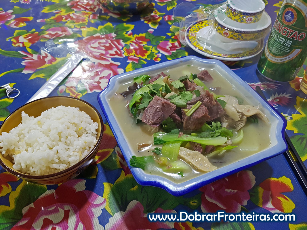 Prato de sopa de vaca e taça de arroz e cerveja chinesa em restaurante na China