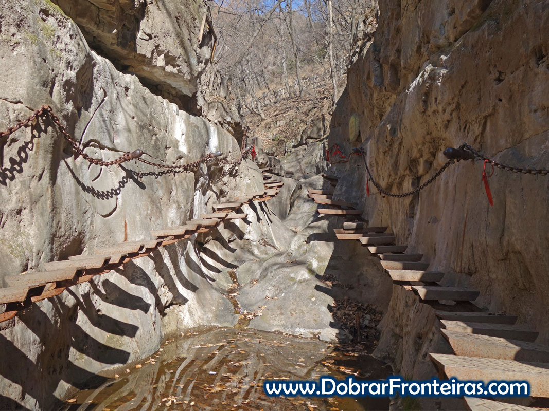 Degraus de ferro suspensos sobre ribeiro em Quixian, Mianshan, China