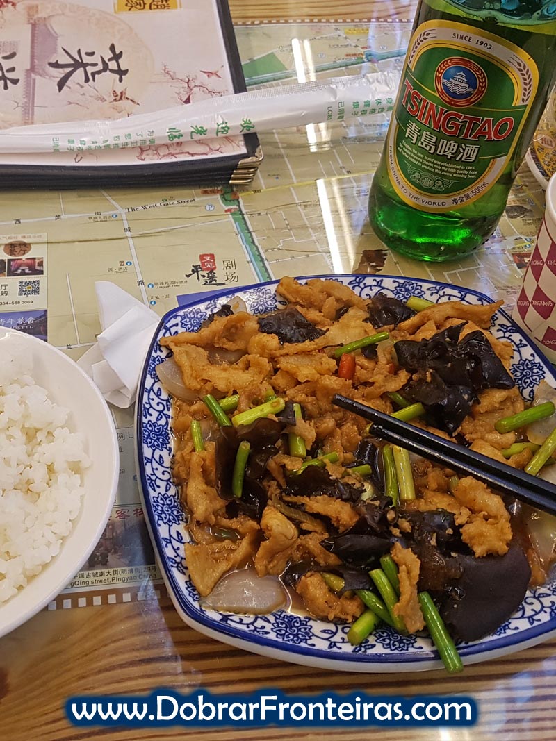 Prato como comida chinesa, arroz e cerveja Tsingtao em restaurante na cidade de Pingyao