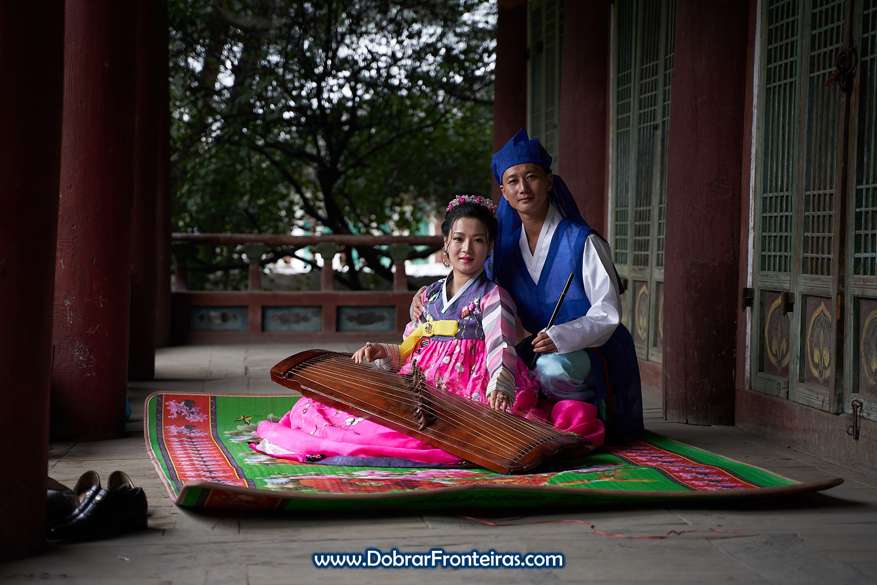 Casal de noivos com roupa tradicional da Coreia do Norte e instrumento musical
