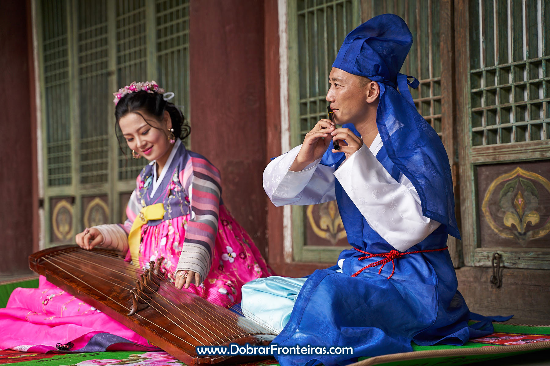 Casal de noivos com roupa tradicional da Coreia do Norte e instrumento musical