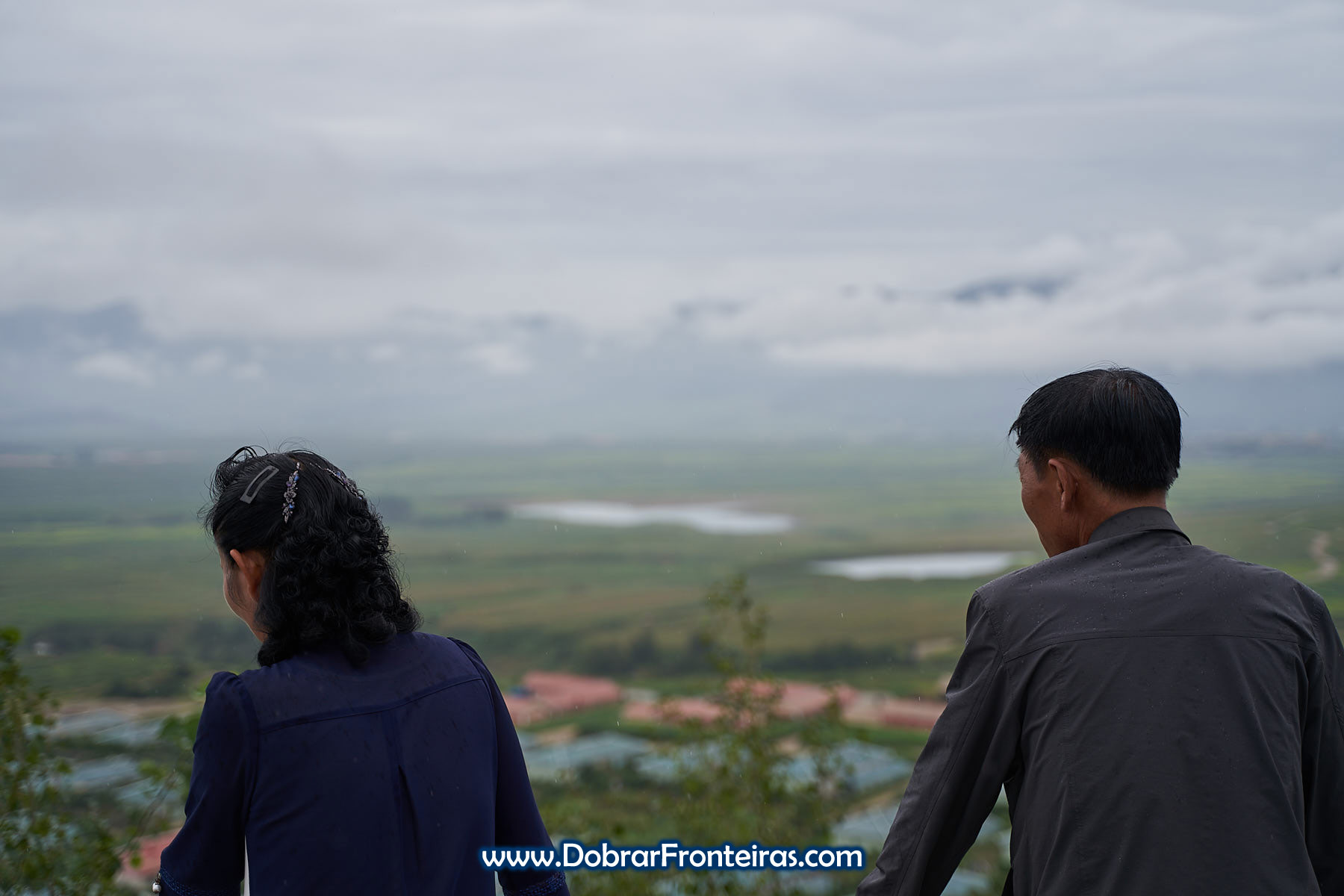 Norte coreanos a observar a paisagem em miradouro