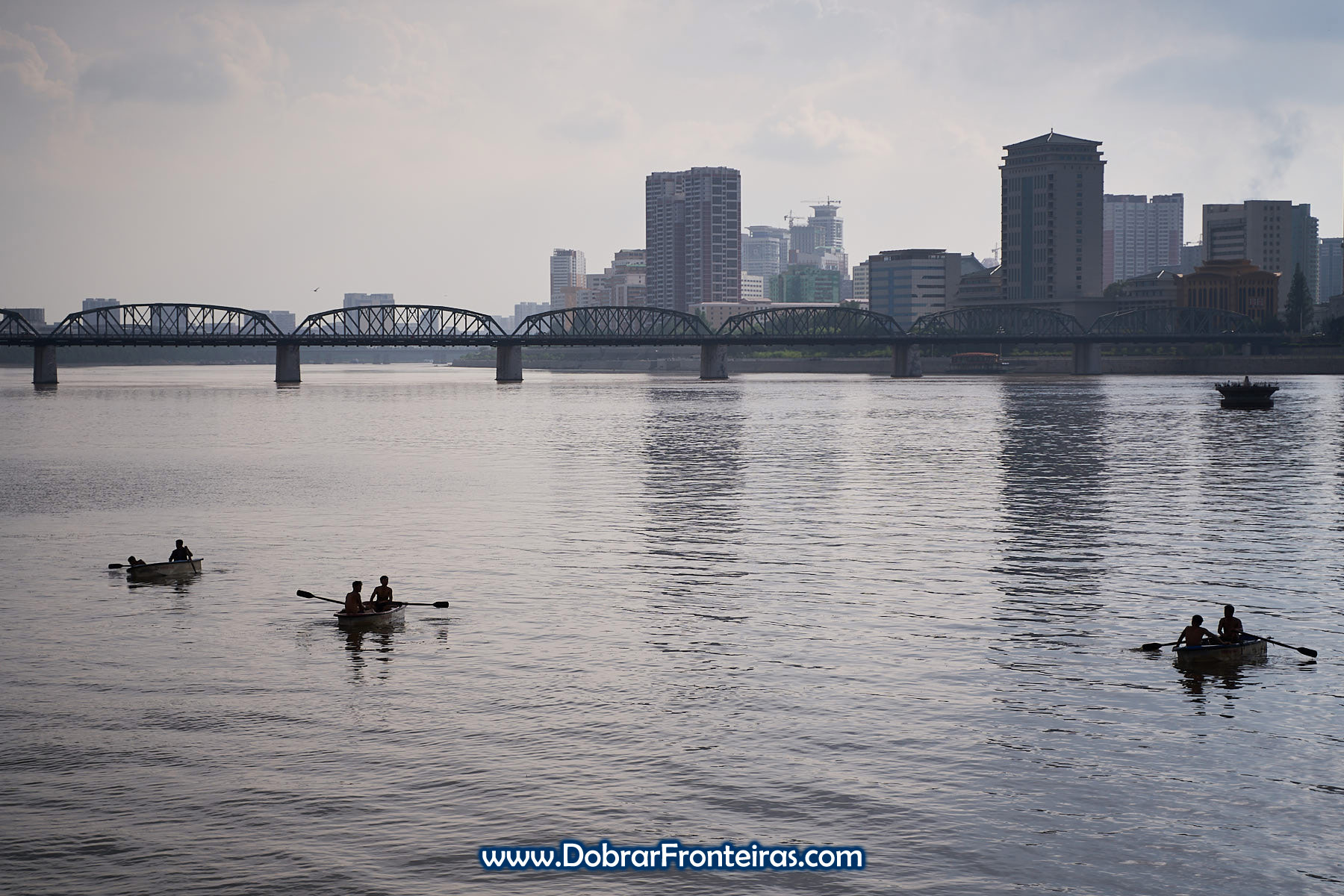Barcos no rio Taedong com ponte ao fundo