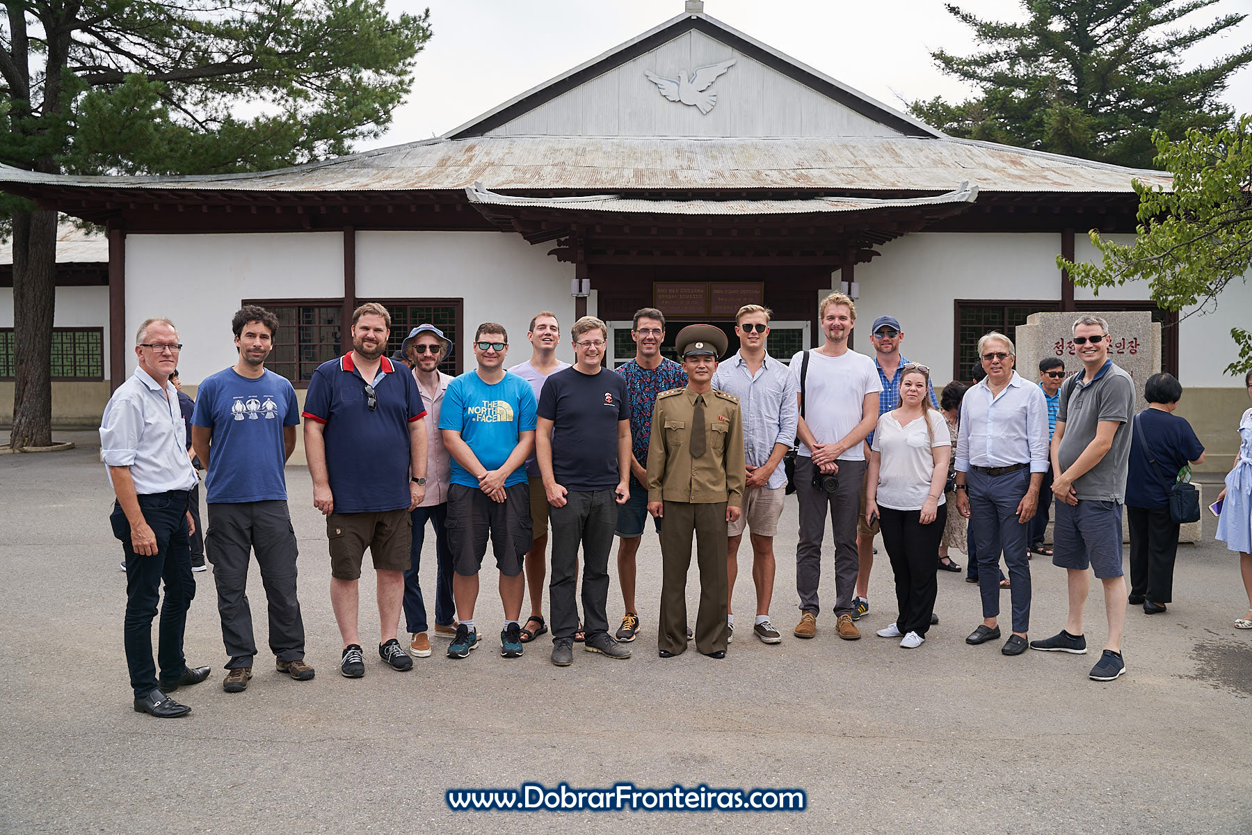 Fotografia de grupo de turistas com militar na DMZ Coreia do Norte