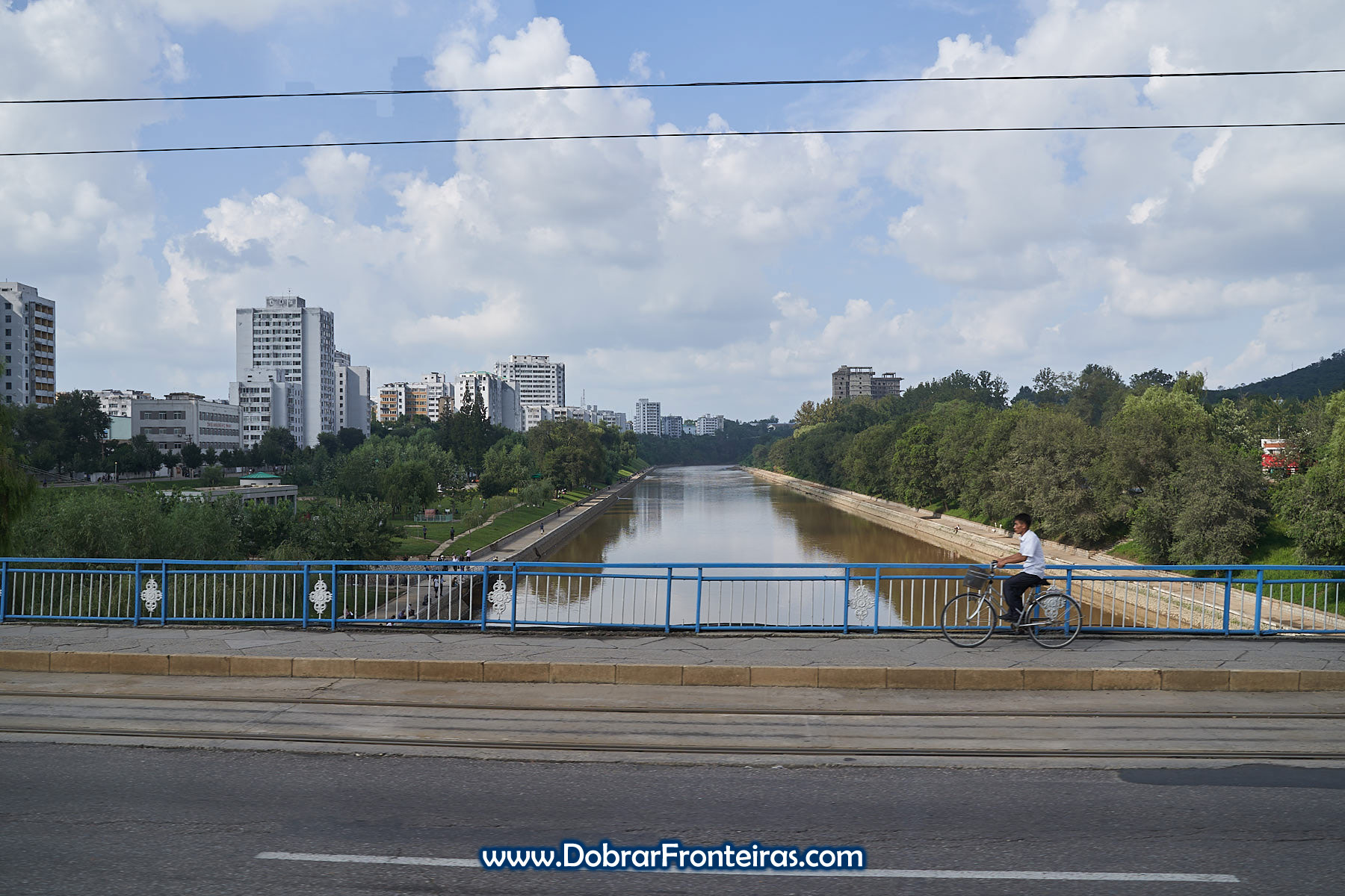 Homem de bicicleta sobre ponte em Pyongyang