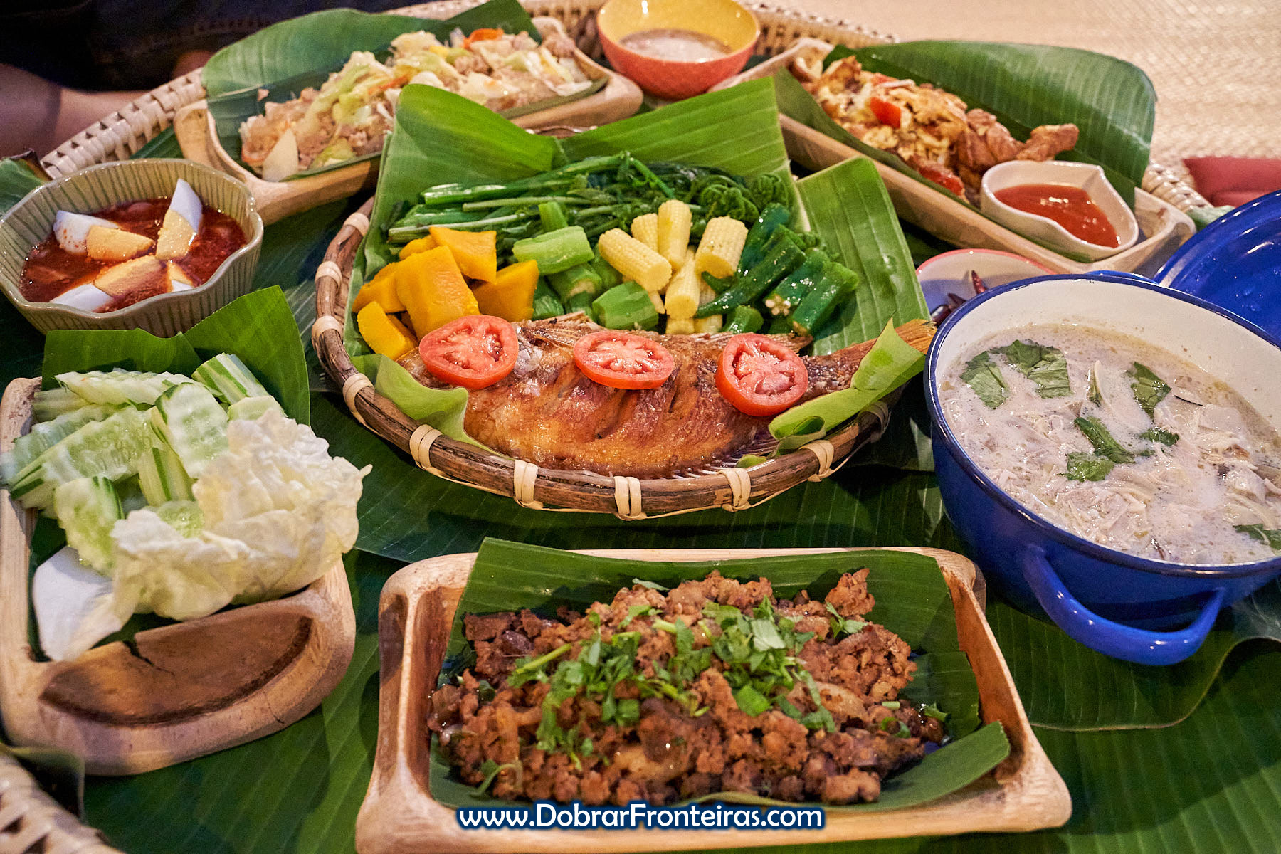 refeição tailandesa com peixe sobre folhas de bananeira e bambu