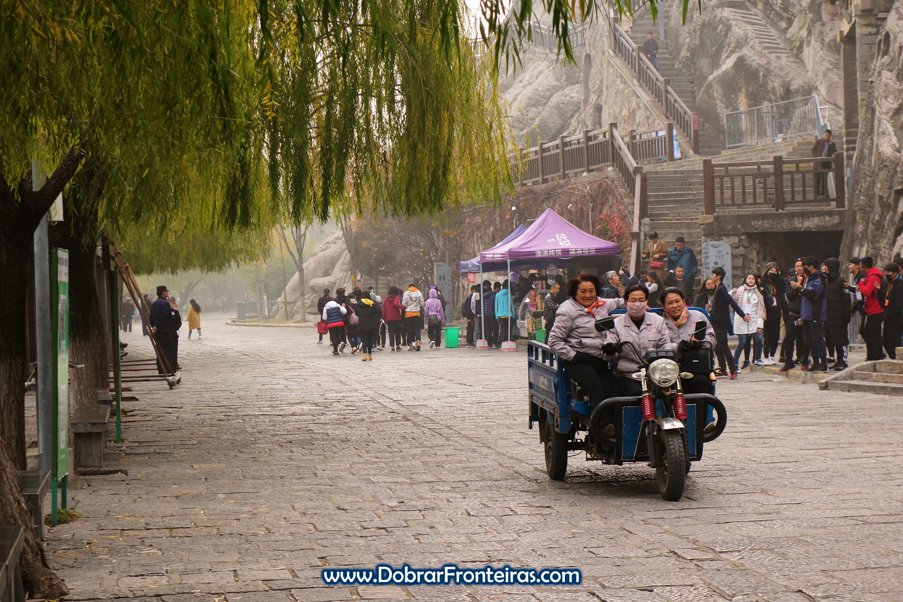 Senhoras chinesas alegres de mota junto de turistas