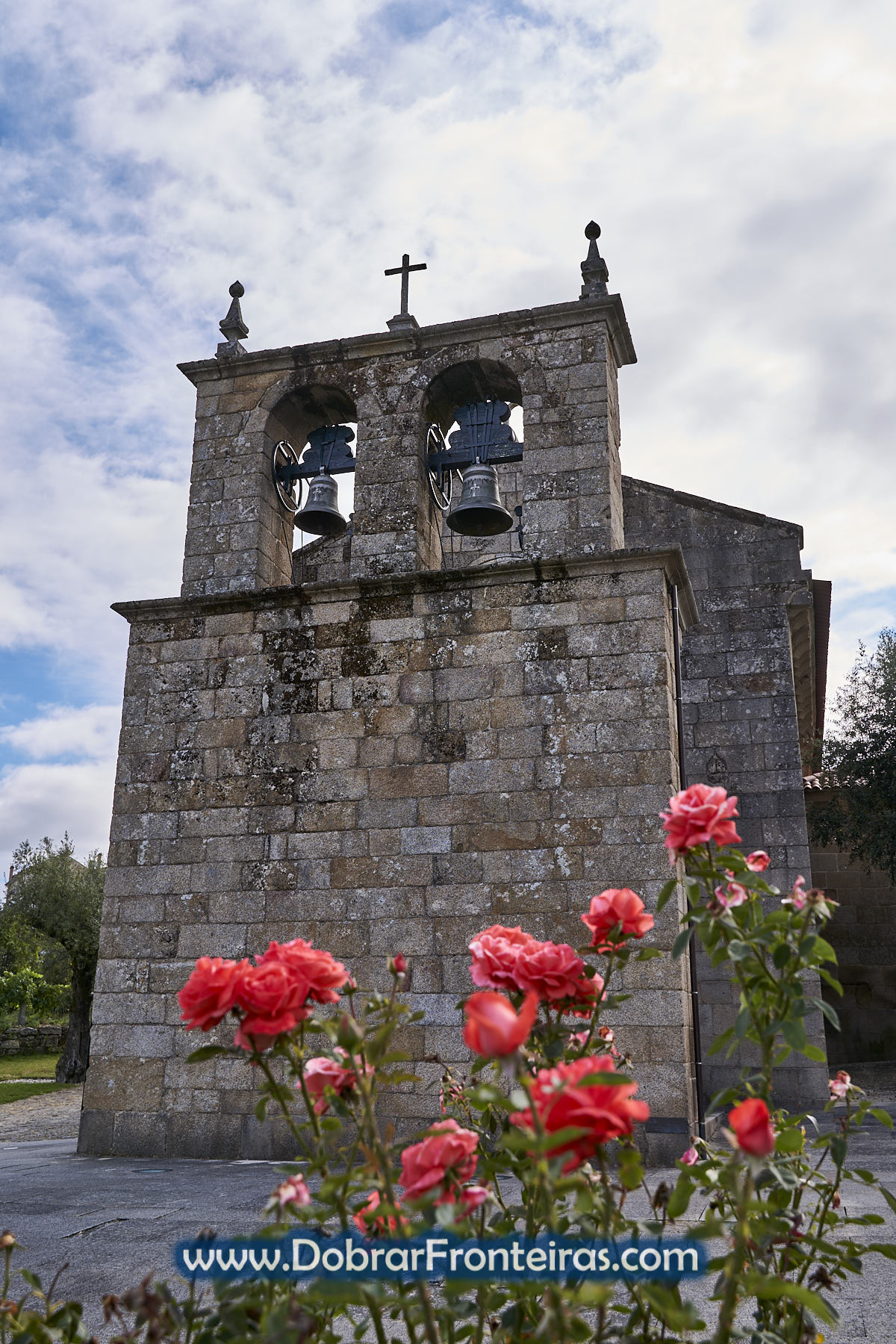 Torre de igreja com sinos e rosas